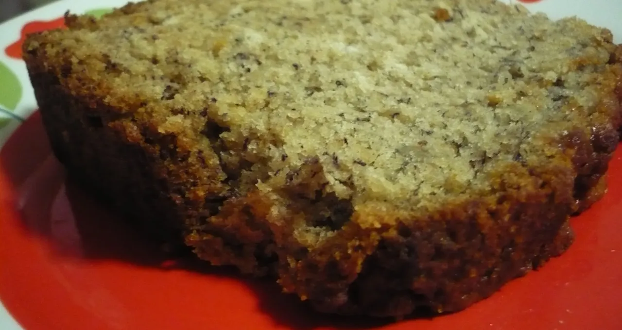 Slice of banana bread on a red plate with a floral rim
